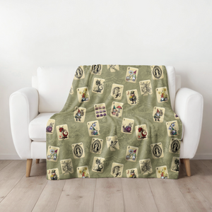 Fairytale Mah Jongg Blanket on Green, draped over a white armchair.