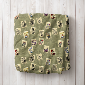 Fairytale Mah Jongg Blanket on Green, draped over a white armchair.