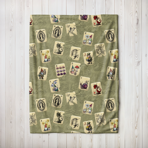 Fairytale Mah Jongg Blanket on Green, draped over a white armchair.